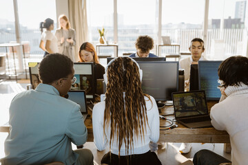 Multiracial male and female programmers working on computer in office