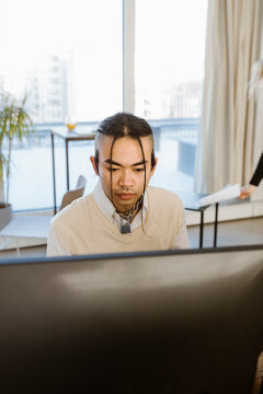 Hipster young male programmer working in creative office