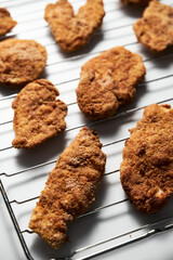 Close Up of Baked Chicken Schnitzel in breadcrumbs schnitzel on grid. 