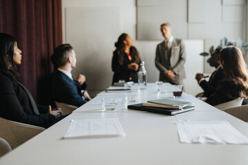 Documents and diaries at desk with business colleagues during meeting in office