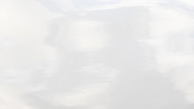 Curvy ripple slowly flowing on a river surface reflect cloud on sky, natural tranquil of bright aqua, blur soft grey fluid, scenic effect upon relaxed steaming water, moving calm tide