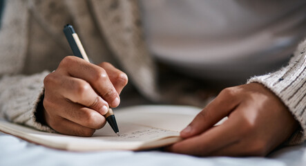 Notebook, bed and person hands for planning, brainstorming and studying notes, education and...