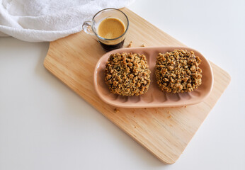 Coffee and muffins with crumble topping on wooden board