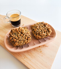 Coffee and muffins with crumble topping on wooden board