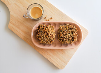 Coffee and muffins with crumble topping on wooden board
