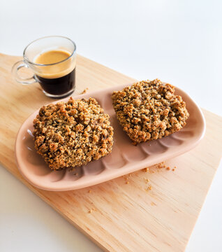 Coffee and muffins with crumble topping on wooden board