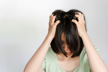 Asian woman itchy head because of dandruff or fungus on scalp on white background.