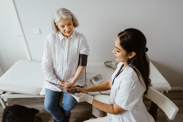 Doctor discussing with senior patient over tablet PC at clinic