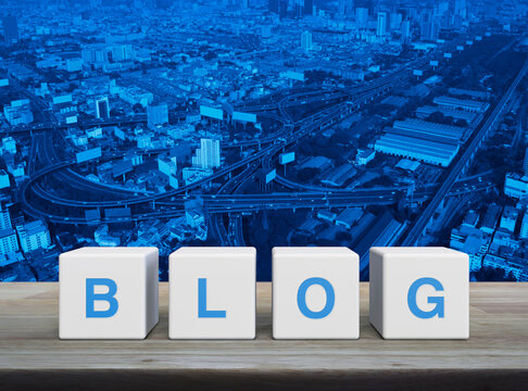 BLOG letter on white block cubes on wooden table over modern city tower, street, expressway and skyscraper, Business communication concept