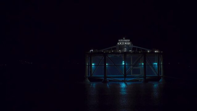 Norwegian Offshore Fish Farming - Transporting The Salmon Fish Farm In The Fjord At Night. - wide