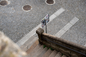 Top view of the street with paving stones, stone stairs and road sign