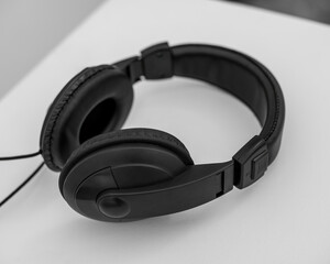 Fototapeta na wymiar Black wireless over-ear headphones on light wooden background.