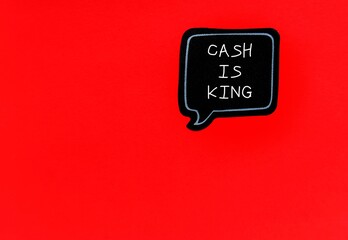 Black sticker on copy space red background with handwritten text CASH IS KING, means importance of cash flow in the overall fiscal health of a business
