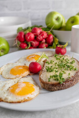 Fried eggs with buttered sourdough bread and cress on a plate
