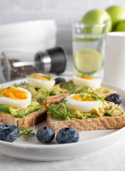 Avocado egg sandwich on whole grain toast with cress