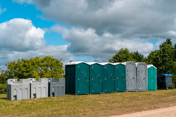 Fototapeta na wymiar Portable mobile toilets and plastic hand washing sink stations on the public park