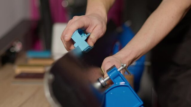 Man sharping ski edges with sharpening tool