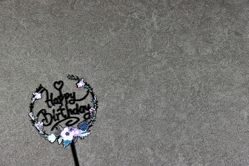 happy birthday text concept with ribbon isolated on grunge gray background