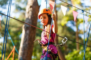 Smiling little girl on the playground, climbing rope net