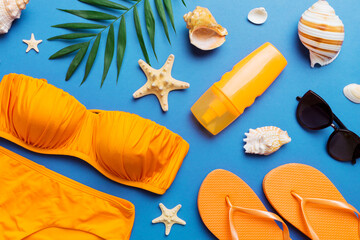 Woman swimwear and beach accessories flat lay top view on colored background Summer travel concept. bikini swimsuit, straw hat and seasheels. Copy space Top view