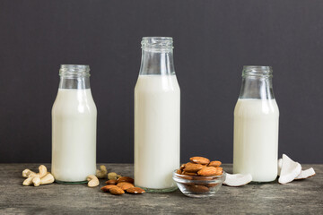 Set or collection of various vegan milk almond, coconut, cashew, on table background. Vegan plant based milk and ingredients, top view