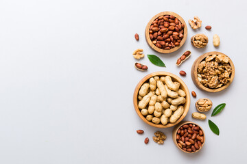 Walnut kernel halves with peanut, in a wooden bowl. Close-up, from above on colored background. Healthy eating groundnut concept. Super foods with copy space