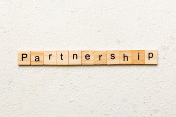 partnership word written on wood block. partnership text on cement table for your desing, concept