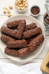 Tasty chocolate bars with caramel and nuts on white table, flat lay