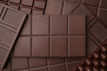 Many tasty chocolate bars as background, top view