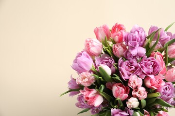 Beautiful bouquet of colorful tulip flowers on beige background, top view. Space for text