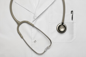 Stethoscope on white medical uniform, top view