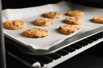 Baking delicious chocolate chip cookies in oven, closeup