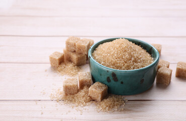 Refined and granulated brown sugar on white wooden table, closeup. Space for text