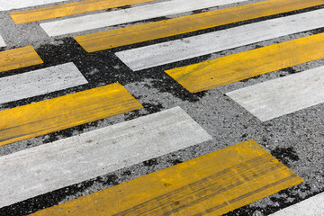 Yellow white stripes over asphalt street pavement. Pedestrian crossing