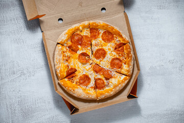 Fototapeta Pepperoni pizza in box on a light background obraz
