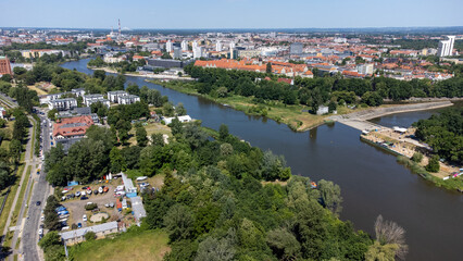 Aerial view, general cityscape of Wroclaw city, Poland. Trees surrounding Odra River. - obrazy, fototapety, plakaty