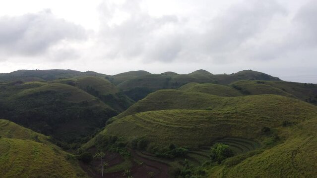 aerial, verdant Teletubbies Hills in Nusa Penida Tropical Island, Bali indonesia.
Used for Terrace Plantation farming, and also a Tourist Attraction for its unique geologic Cone shape.