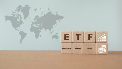 wooden cube with ETF text , Exchange Traded Fund, increasing graph and icon icon on world map...