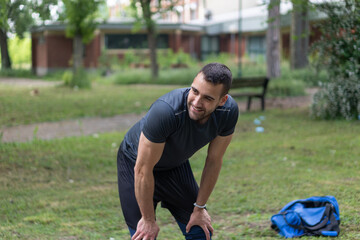 Fototapeta premium Young man taking a break from training outside. 