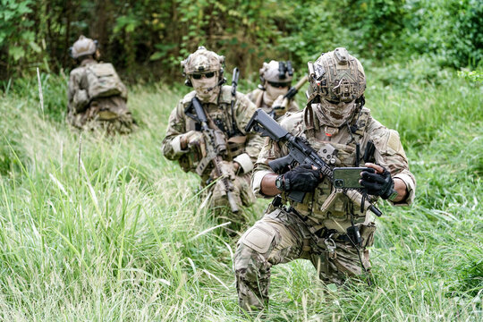 Infantry soldier shooting during military combat training.. Army elite troops marksman, special operations forces sniper wearing mask 
