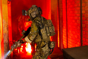 Army elite troops marksman, special operations forces sniper wearing mask and glasses, night-vision or infrared thermal imaging device on helmet, holding service rifle with optical sight and silencer