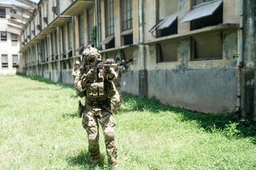 Army elite troops marksman, special operations forces sniper wearing mask and glasses, night-vision or infrared thermal imaging device on helmet, holding service rifle with optical sight and silencer