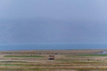 Obraz premium grasslands, Lake Moriri, mountains, cloudy sky. Beautiful scenery at the mountain lake, Ladakh, India