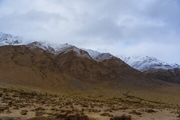 Fototapeta na wymiar snow covered mountains, cloudy sky at the way from Moriri lake to Leh city, Ladakh, India