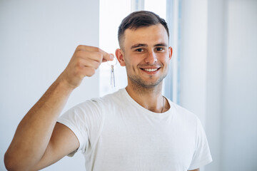 Young man holding keys from his new apartment