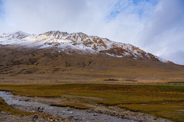 Fototapeta na wymiar withered grass field, the mountain and cloud sky at Tso Kar lake, Beautiful scenery along the way at Ladakh, India. The Tso Kar or Tsho kar is a fluctuating salt lake
