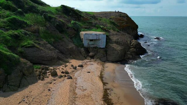 pillbox firing point on the sandy shore of the blue sea - Aerial flying drone video  