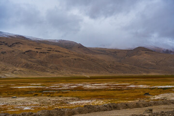 Fototapeta na wymiar withered grass field, the mountain and cloud sky at Tso Kar lake, Beautiful scenery along the way at Ladakh, India. The Tso Kar or Tsho kar is a fluctuating salt lake