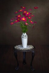 Still life with bouquet of red daisies on a dark background