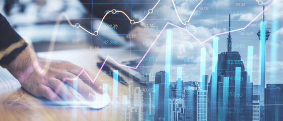 Close up of male hands using laptop mouse while leaning on desk on abstract wide city background with forex chart and grid. Financial growth, technology and communication concept. Double exposure.